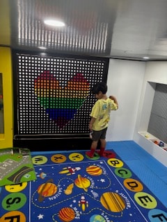 Child exploring the interactive peg wall at Kids Fun Town